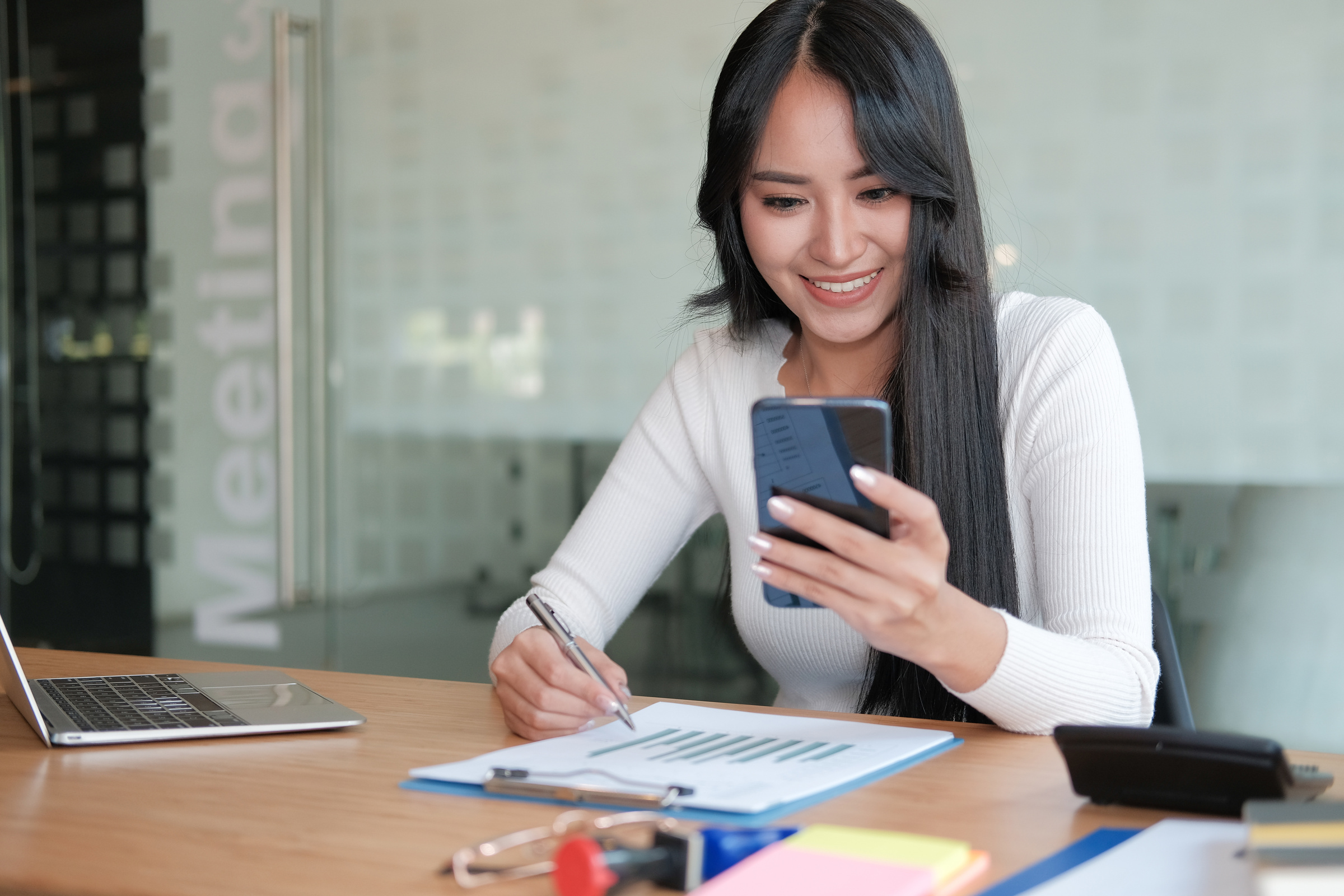 Woman Using Mobile Phone At Work